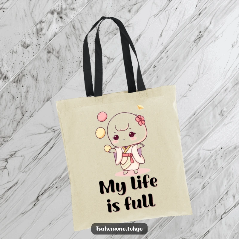 Funny tote bag with a cute mochi character in a pastel kimono, balancing colorful dumplings while juggling with great concentration.